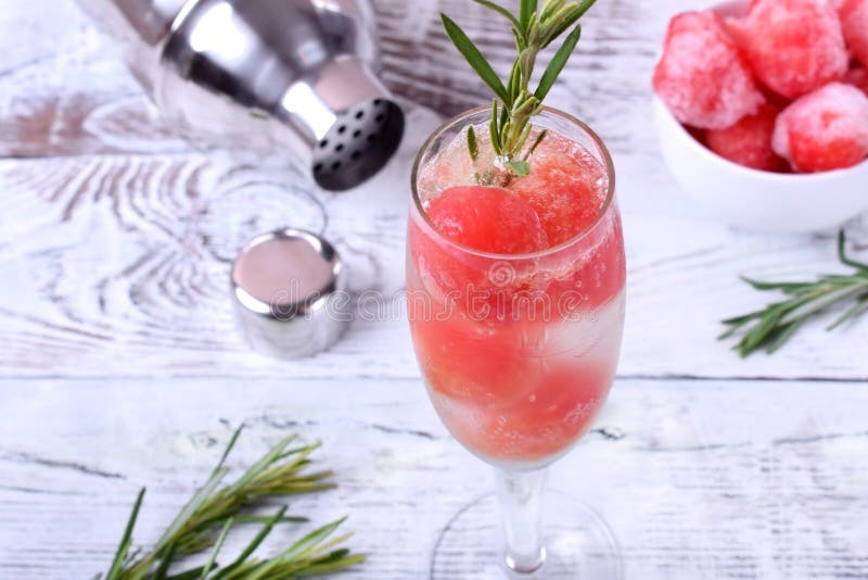 Sparkling cocktail with watermelon balls and rosemary in a champagne glass