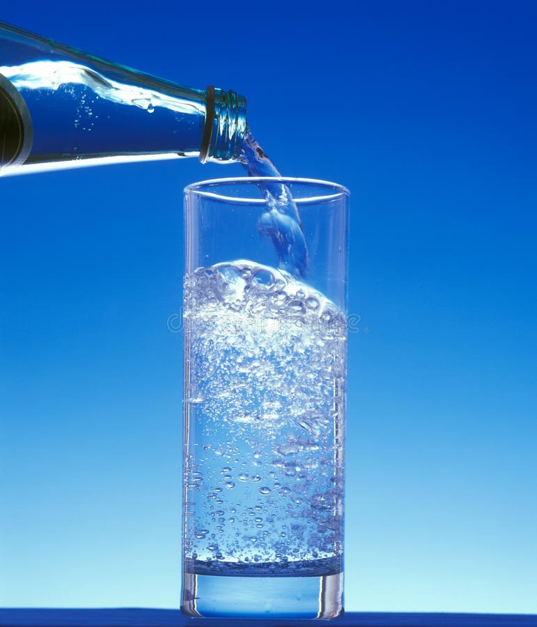 Water Being Poured in a Glass Against White Background Stock Photo