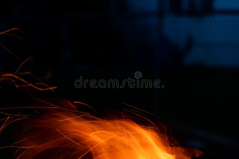 Sparks and flame erupt from the top of a chimney starter fire on a backyard grill stock photography
