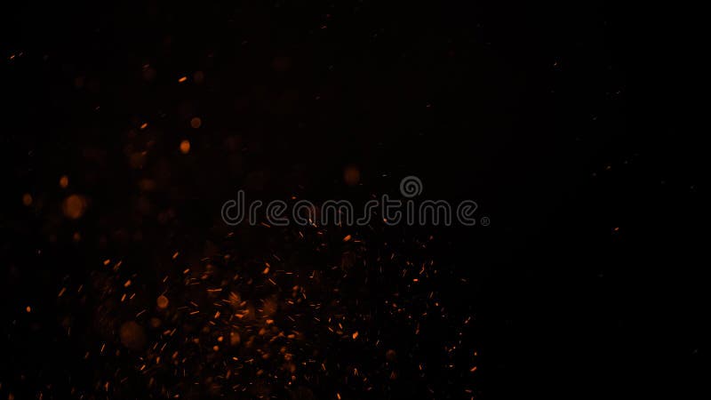 Sparks like particles floating in air over black background royalty free stock photo