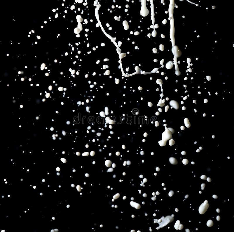 Spatten van witte melk geïsoleerd op een zwarte achtergrond royalty-vrije stock foto