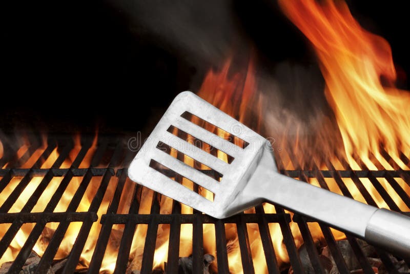 Spatula on the BBQ Hot Grill. Flames of Fire on the Background. Spatula on the BBQ Hot Grill. Flames of Fire on the Background