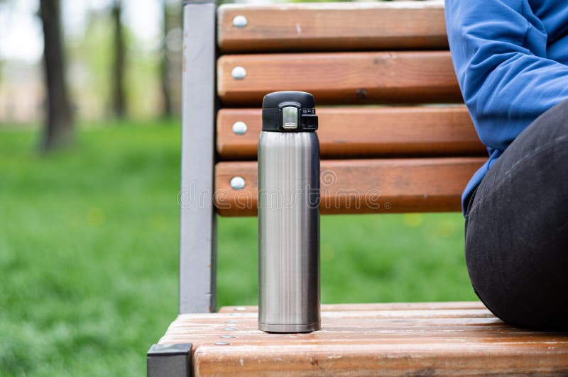 Walk in the park with a thermos. With a thermos on a bench in the park. Tea or coffee to go for a walk. A man on a bench and a thermos. Walk in the park with a thermos. With a thermos on a bench in the park. Tea or coffee to go for a walk. A man on a bench and a thermos.