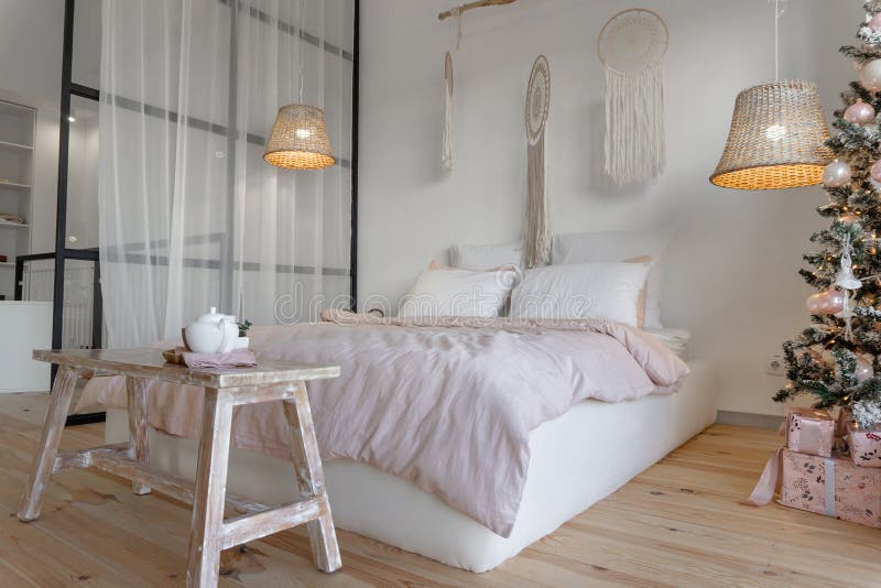 Spaziosi interni della camera da letto bianca decorati con albero di Natale fotografia stock