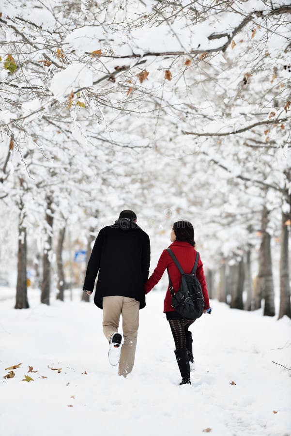 Young pretty women and boy walking in winter park. happiness couple. Happy winter travel couple. Young pretty women and boy walking in winter park. happiness couple. Happy winter travel couple