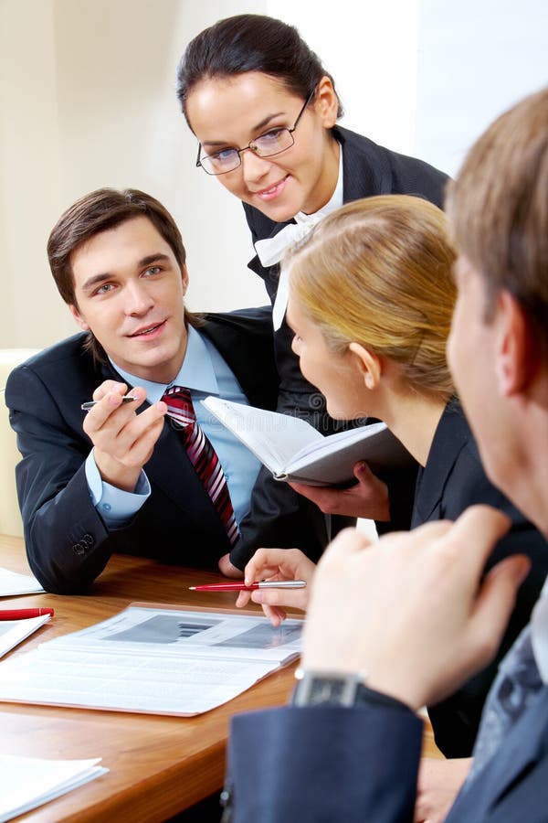 Portrait of handsome businessman explaining something to his colleagues with smart woman near by. Portrait of handsome businessman explaining something to his colleagues with smart woman near by