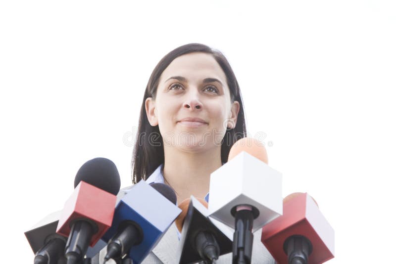 Woman outside behind bank of microphones. Woman outside behind bank of microphones