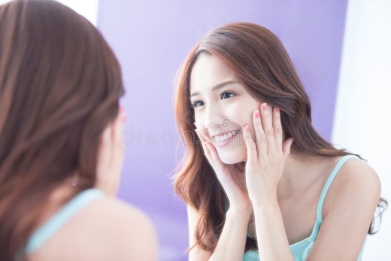 Specchio di sguardo della donna di sorriso fotografia stock Specchio di sguardo della donna di sorriso fotografia stock