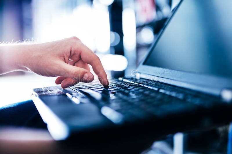 IT specialist pressing button on keyboard in big data center