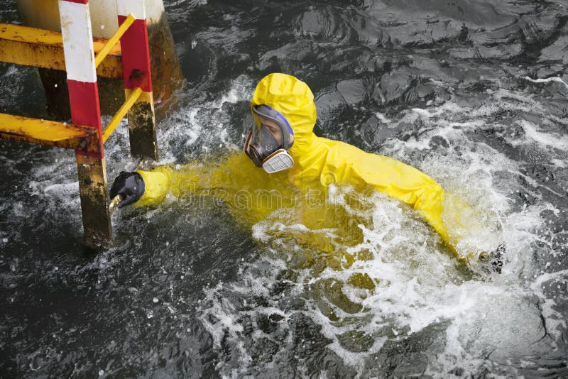Pracovník v odbornej, ochranný odev v morskej vode sa snaží dosiahnuť rebrík, aby zachránil život.