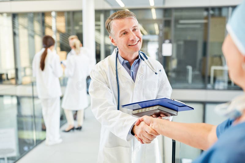 Specialist shaking hands with a surgeon stock photo