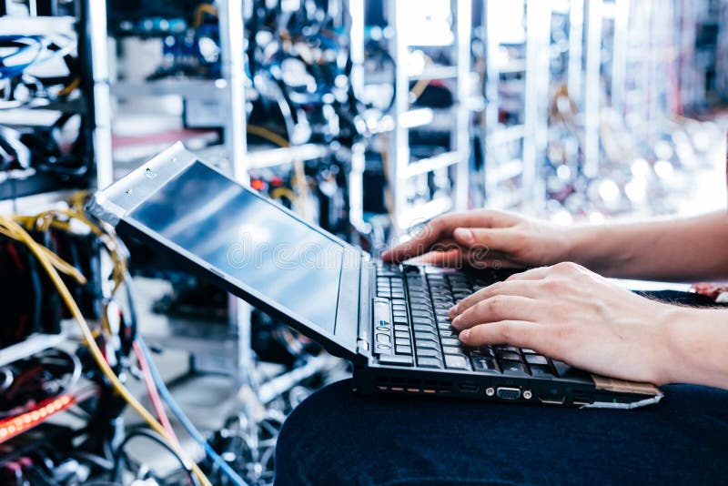 IT specialist working on computer in bitcoin and crypto currency mining farm stock photos