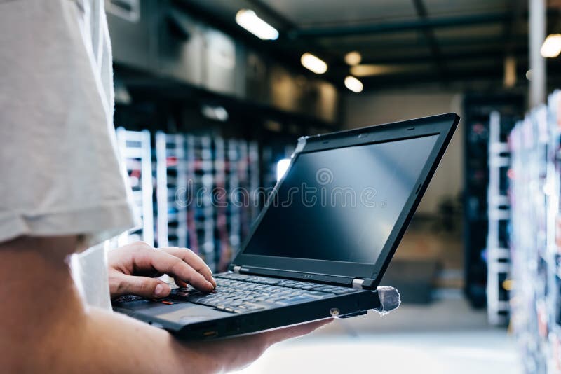 IT specialist working on computer in bitcoin and crypto currency mining farm stock photo