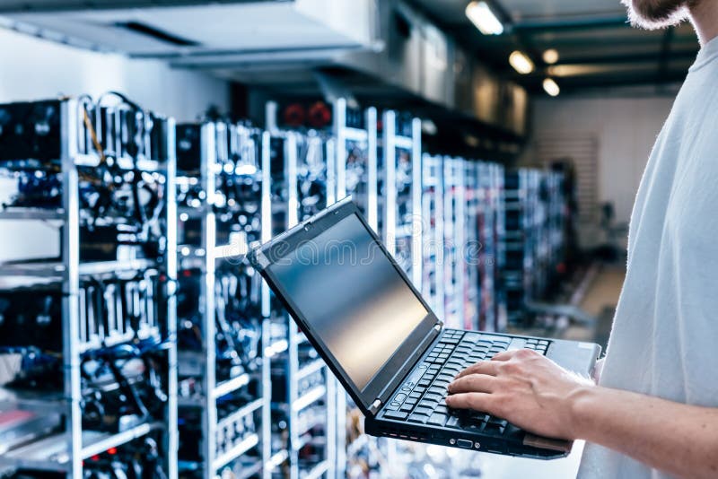 IT specialist working on computer in bitcoin and crypto currency mining farm stock images