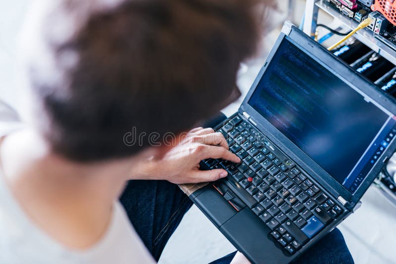 IT specialist working on computer in bitcoin and crypto currency mining farm royalty free stock photography