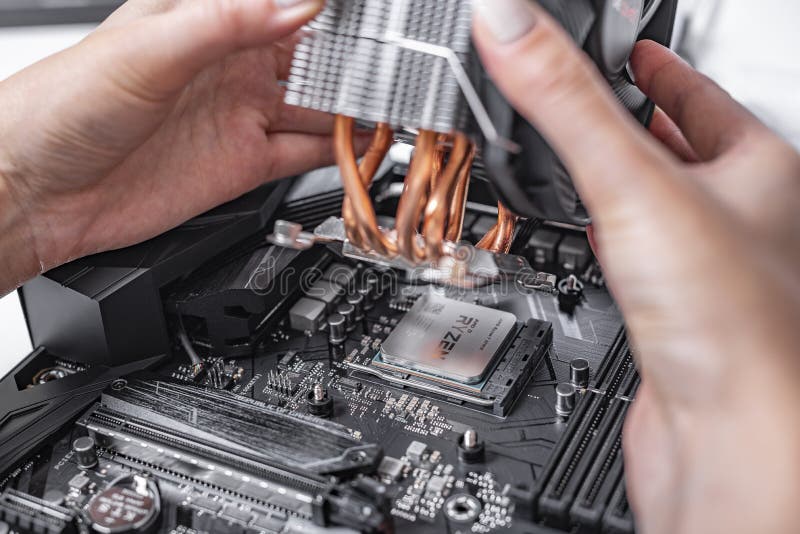 Specialisten installerar en kylare på den nya processorn Ryzen 7 2700X mot bakgrunden av ett datormoderkort royaltyfria bilder Specialisten installerar en kylare på den nya processorn Ryzen 7 2700X mot bakgrunden av ett datormoderkort royaltyfria bilder