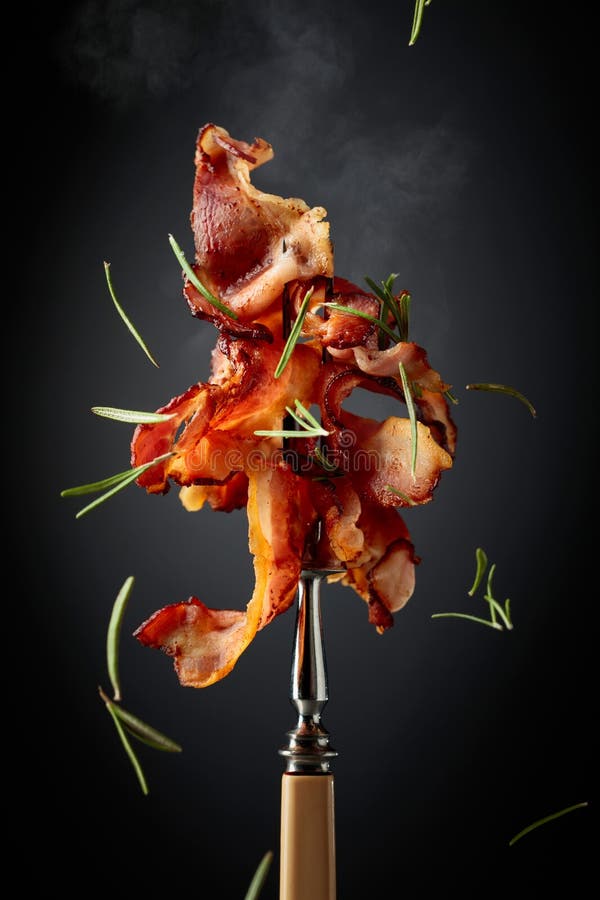 Speck mit Rosmarin auf einer Gabel stockbild