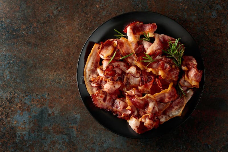 Speck mit Rosmarin auf schwarzer Platte lizenzfreies stockfoto
