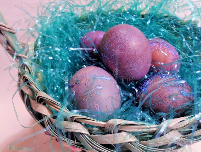 Questo è un close up immagine di fatti in casa viola maculato tinti di uova di Pasqua in un cesto tessuto.