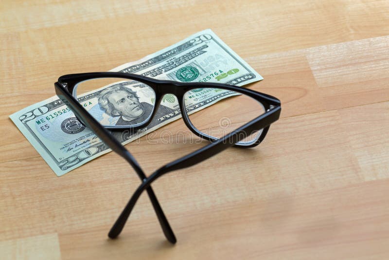 Spectacles with black frame, eye glasses on 20 USD dollar banknote money bill