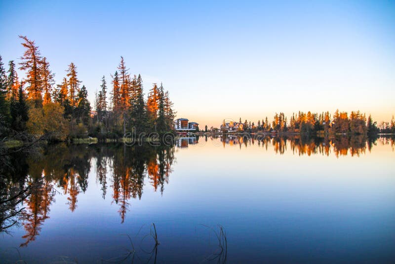 Spectacular Mountain lake Strbske pleso Strbske lake with mirror reflection of trees in lake at sunrise