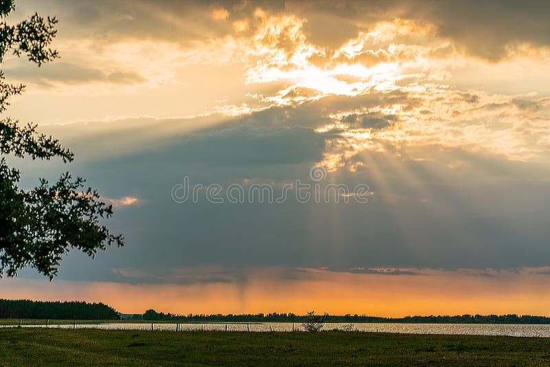 Spectacular sunset over lake Guelpe GÃ¼lper See with sunrays shining through thick clouds