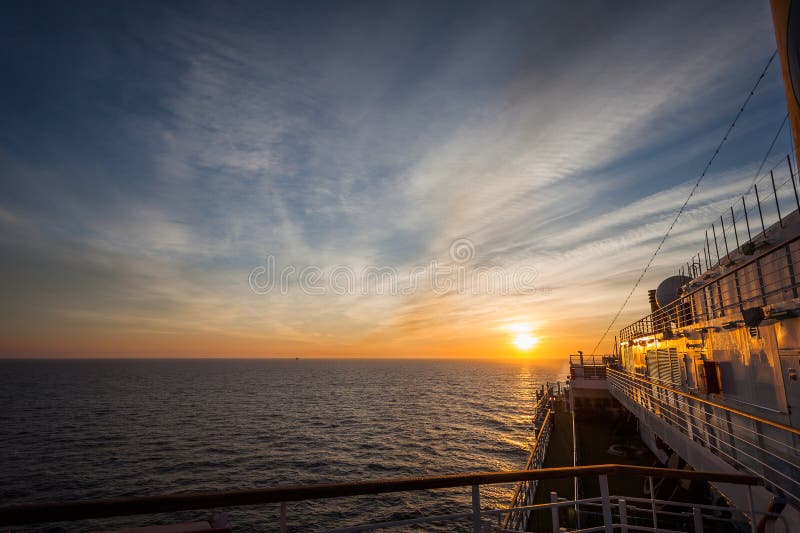 Spectacular sunset over sea horizon seen from the upper deck of a cruise ship stock photos Spectacular sunset over sea horizon seen from the upper deck of a cruise ship stock photos