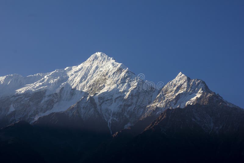 Spectacular view of very high snowy mountains with a beautiful blue sky in Annapurnas, Nepal. Nilgiri Peak, trekking round the royalty free stock photo Spectacular view of very high snowy mountains with a beautiful blue sky in Annapurnas, Nepal. Nilgiri Peak, trekking round the royalty free stock photo