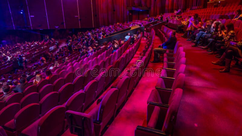 Spectateurs se rassemblent dans l'auditorium et regardent le spectacle dans le théâtre timelapse. grande salle avec fauteuils roug banque de vidéos