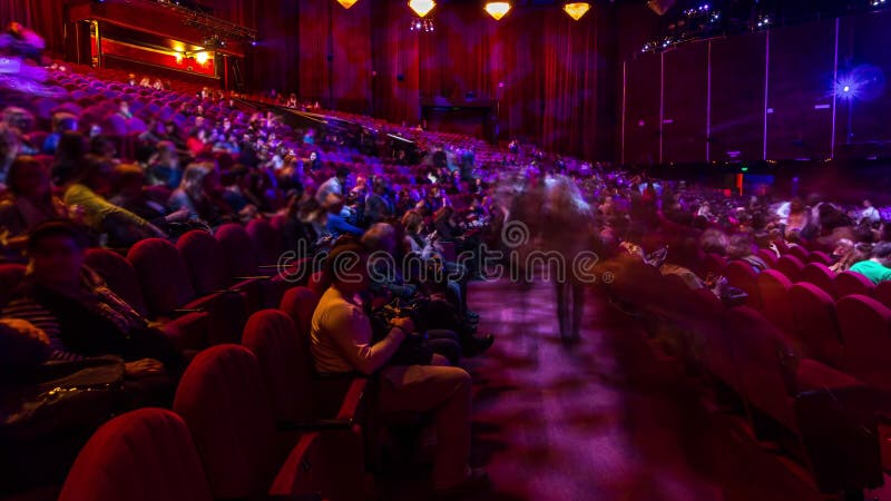 Spectateurs se rassemblent dans l'auditorium et regardent le spectacle dans le théâtre timelapse. grande salle avec fauteuils roug clips vidéos