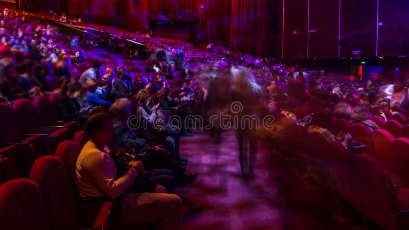 Spectateurs se rassemblent dans l'auditorium et regardent le spectacle dans le théâtre timelapse. grande salle avec fauteuils roug banque de vidéos