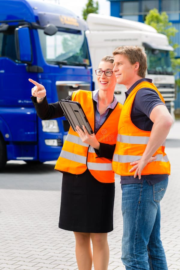 Spedizioniere davanti ai camion su un deposito fotografia stock Spedizioniere davanti ai camion su un deposito fotografia stock