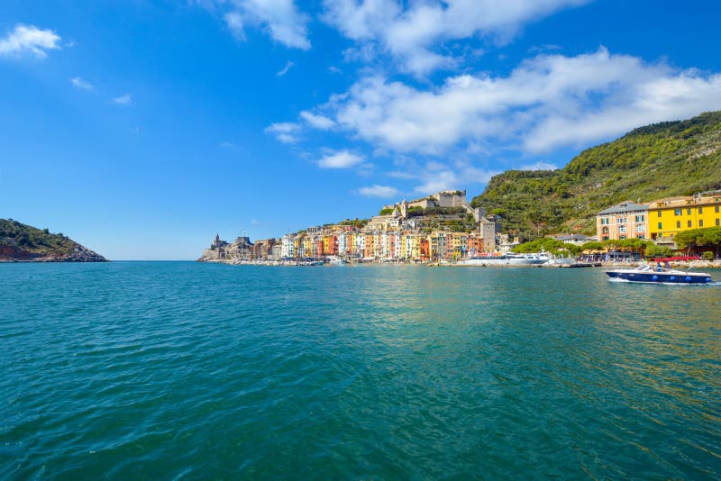 A speed boat crosses the colorful harbor of the village of Portovenere, Italy, on the Ligurian Coast near Cinque Terre. royalty free stock photos A speed boat crosses the colorful harbor of the village of Portovenere, Italy, on the Ligurian Coast near Cinque Terre. royalty free stock photos