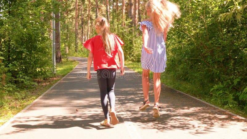 Speelgoedmeisjes lopen weg zomerpark weg achteraanzicht