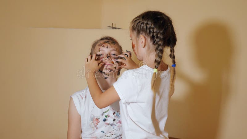 Speelse meisjes die elkaar met verven kleuren