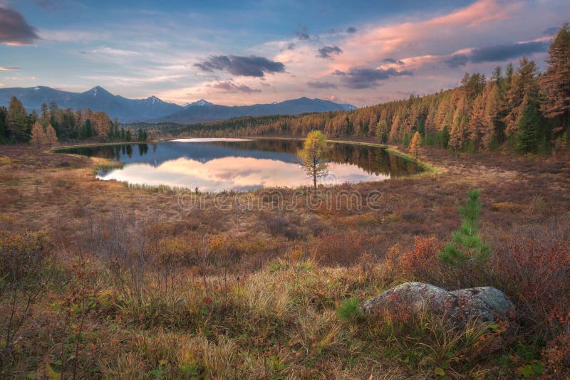 Spegelyttersida vinkel Autumn Landscape With Mountain Range för tidig solnedgång för sjö bred på bakgrund royaltyfria foton Spegelyttersida vinkel Autumn Landscape With Mountain Range för tidig solnedgång för sjö bred på bakgrund royaltyfria foton