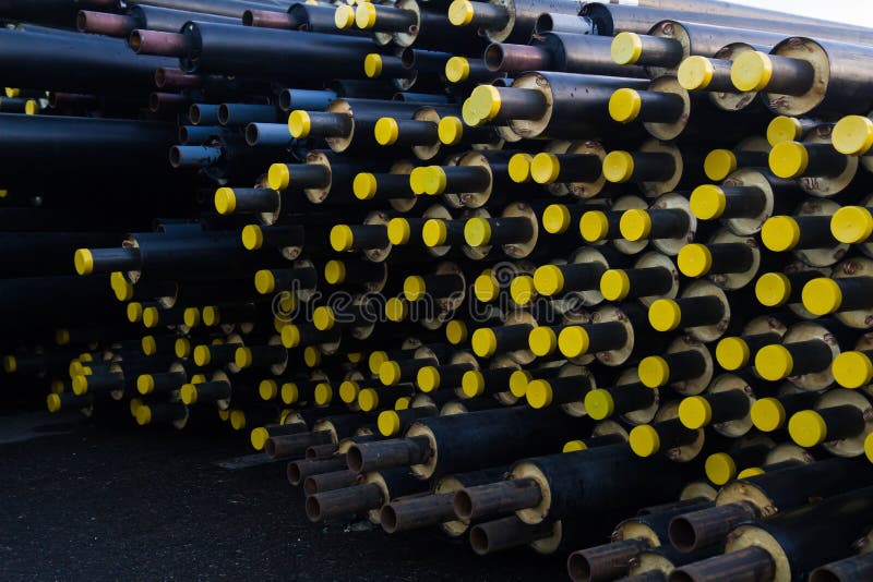 Speicherte viel schwarzes Stahlrohr mit Wärmedämmung auf Baustelle in einer Kunststoffrohrverpackung, die mit gelben Deckelrohren lizenzfreie stockfotografie Speicherte viel schwarzes Stahlrohr mit Wärmedämmung auf Baustelle in einer Kunststoffrohrverpackung, die mit gelben Deckelrohren lizenzfreie stockfotografie