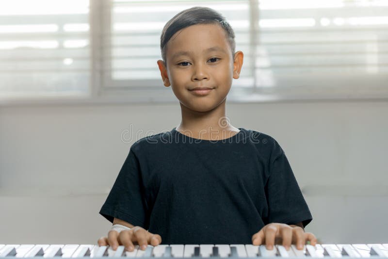 An asian boys at the wounded hands are playing the piano. An asian boys at the wounded hands are playing the piano.