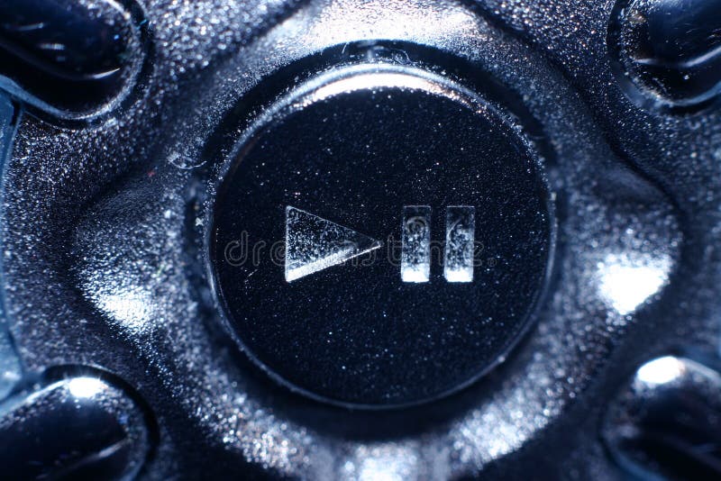 A macro photograph (extreme close up) of a play / pause button. Picture has a very smallow dof (1/10 inch or so) in real life the button is about 1/4 inch . A macro photograph (extreme close up) of a play / pause button. Picture has a very smallow dof (1/10 inch or so) in real life the button is about 1/4 inch .