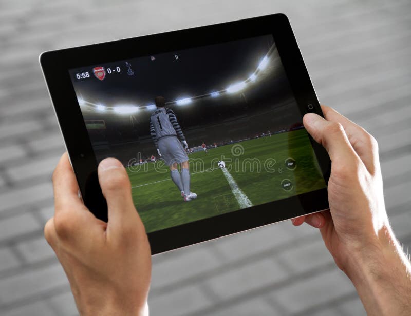 A man outdoors play in the game FIFA football on Apple Ipad2. A man outdoors play in the game FIFA football on Apple Ipad2.