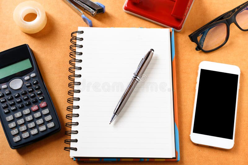 Spese generali della tavola dell'ufficio con il taccuino, penna, telefono cellulare, calc fotografia stock