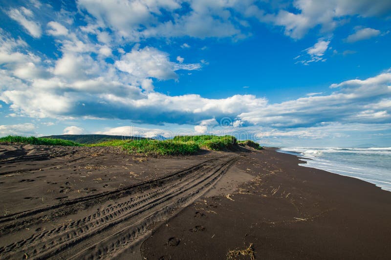 Spiaggia di Halaktyr kamchatka Federazione Russa Spiaggia di sabbia quasi nera di colore di buio dell'oceano Pacifico Montagne di fotografie stock Spiaggia di Halaktyr kamchatka Federazione Russa Spiaggia di sabbia quasi nera di colore di buio dell'oceano Pacifico Montagne di fotografie stock
