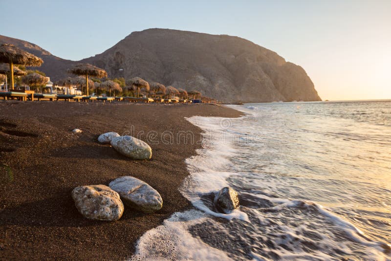 Spiaggia di Perissa durante l'alba sull'isola greca di Santorini fotografia stock Spiaggia di Perissa durante l'alba sull'isola greca di Santorini fotografia stock