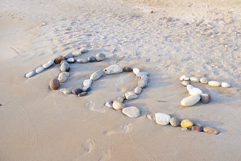 Spiaggia sabbiosa con un'iscrizione dall'isola di Kos delle pietre immagine stock libera da diritti Spiaggia sabbiosa con un'iscrizione dall'isola di Kos delle pietre immagine stock libera da diritti