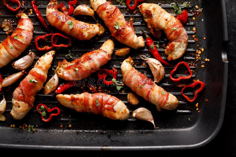 Spice chicken meat, Grilled chicken tenderloin wrapped with bacon with addition chili peppers, garlic and herbs on grill plate