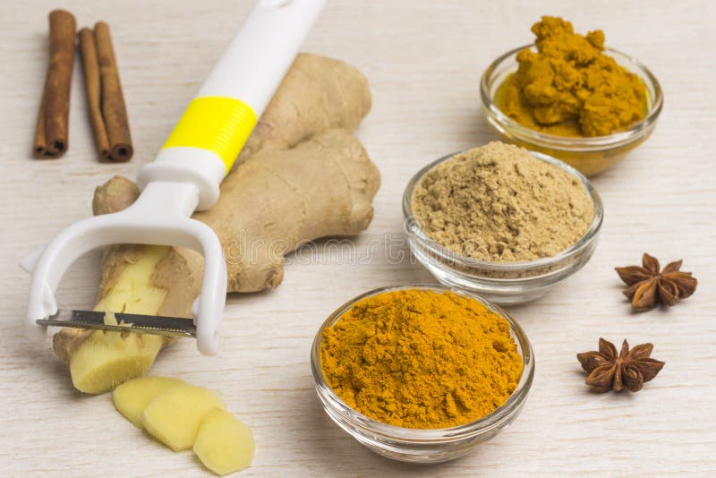 Spice set: ginger root and vegetable cutter, ginger and turmeric powder, turmeric paste on a light background