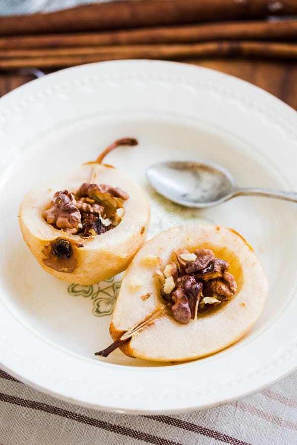Spicy baked pear with walnuts, honey, cinnamon sticks, healthy d