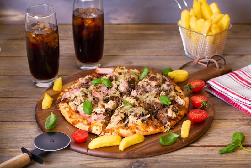 Spicy Beef Chicken and Ham Pizza with Fries and Two Drinks. Stock Image