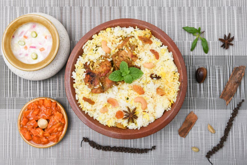 Spicy and delicious chicken biryani in traditional clay pot. Malabar biryani or Hydrabadi chicken biryani, Dum Biriyani, Chicken pulao basmati rice, herbs, raitha for Ramadan Kareem, Eid-Ul-Adha. Chicken dum biryani stock images, royalty-free photos and pictures