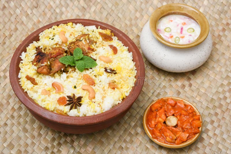 Spicy and delicious chicken biryani in traditional clay pot. Malabar biryani or Hydrabadi chicken biryani, Dum Biriyani, Chicken pulao basmati rice, herbs, raitha for Ramadan Kareem, Eid-Ul-Adha. Chicken dum biryani stock images, royalty-free photos and pictures